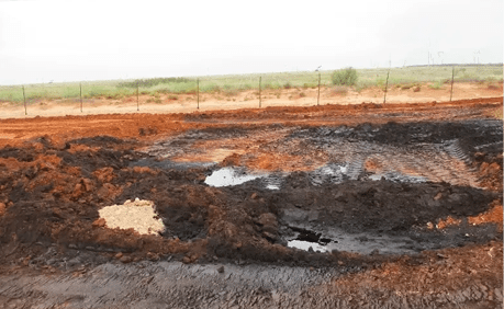 A dirt field with brown and black soil