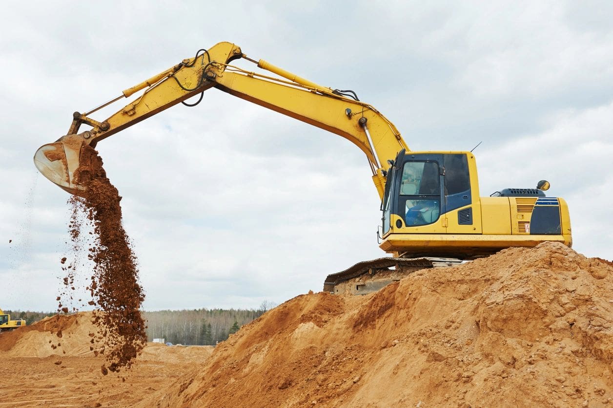 A yellow and black excavator on top of dirt.