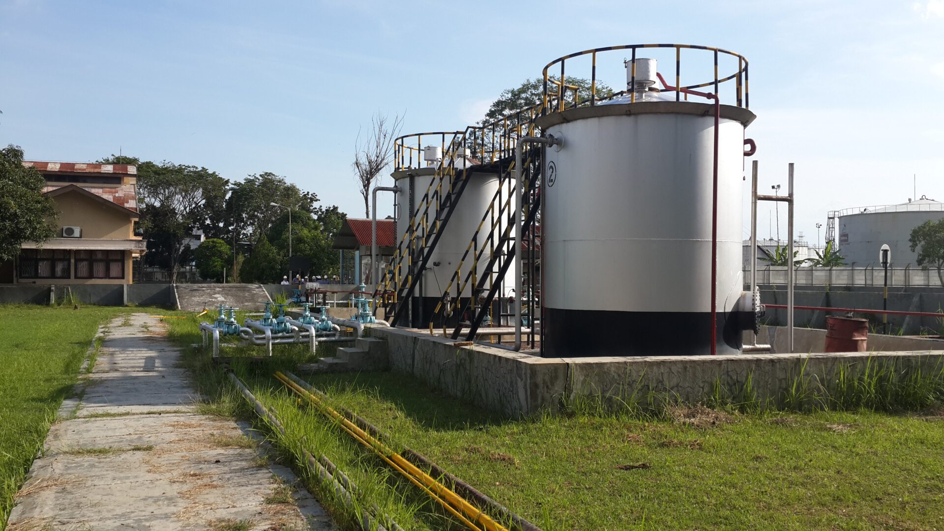 A large metal tank sitting next to a canal.