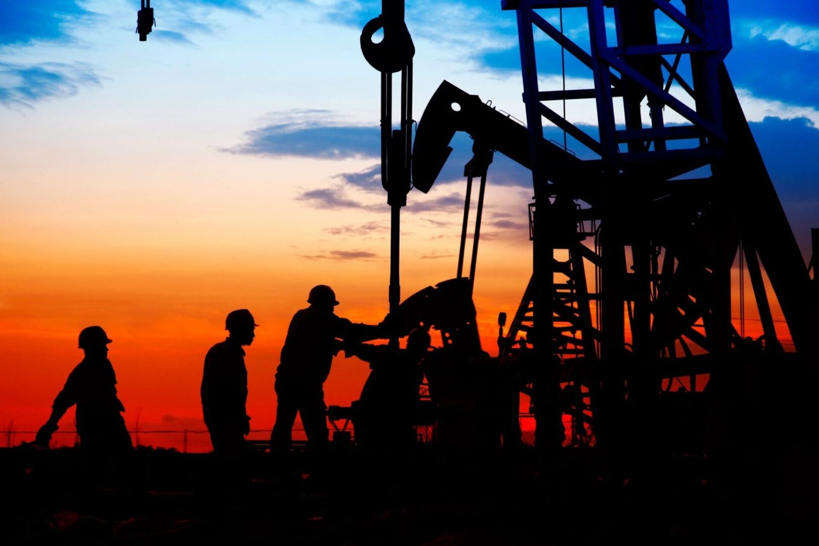 Two men are working on a drilling rig.